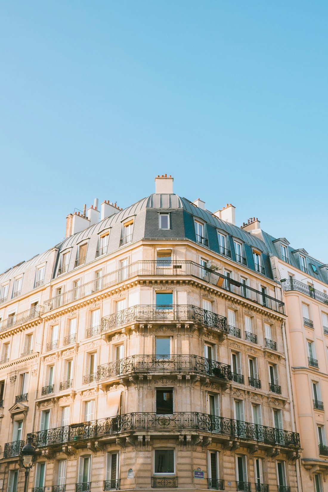 Haussmann-era building facade under a clear sky, Paris